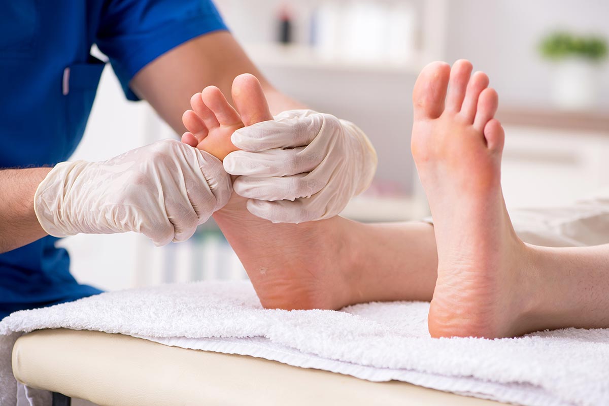 podiatrist treating feet during procedure
