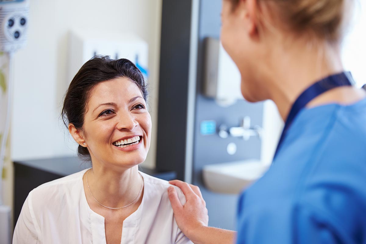 female doctor with smiling female patient